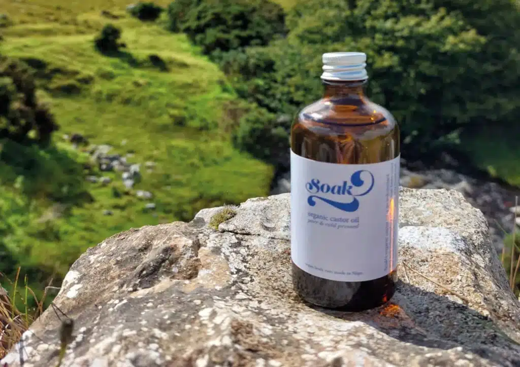 A blue-labeled tincture bottle placed on a rugged rock in the mountains